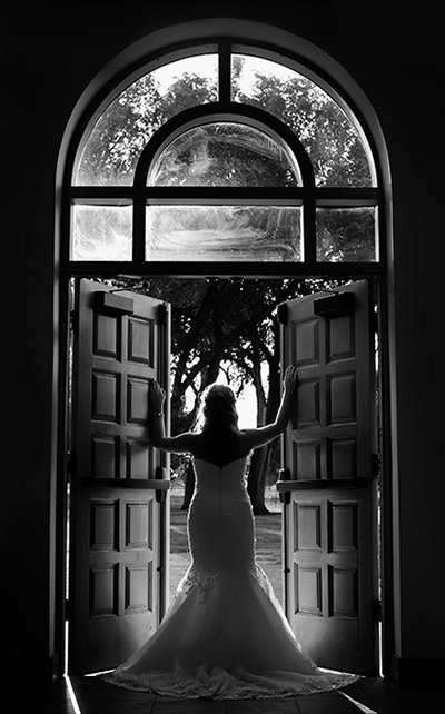 Bride stands shillouetted in a doorway