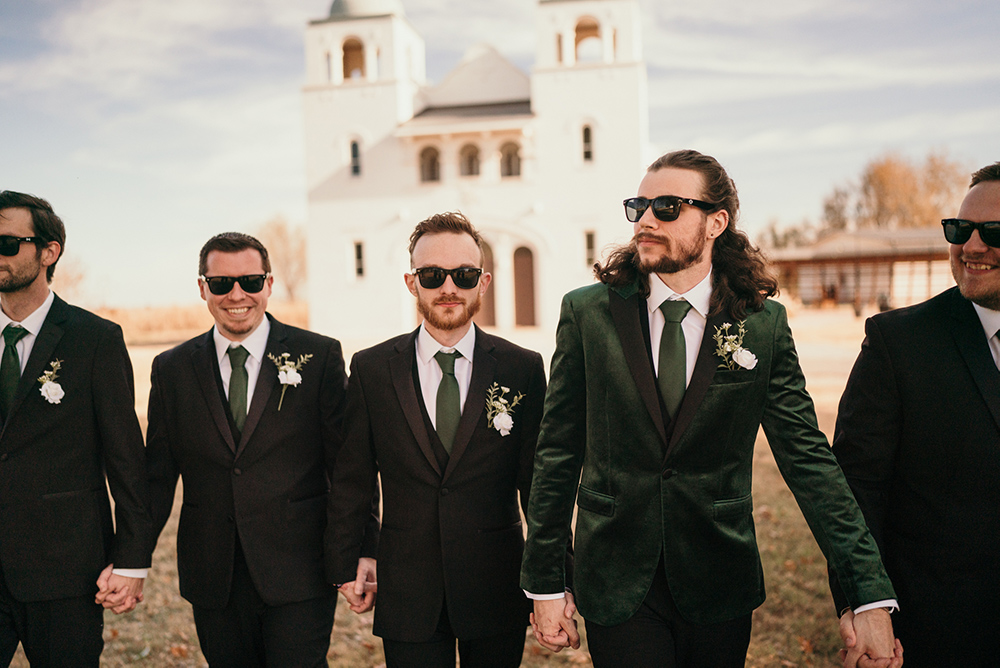 Groomsmen in sunglasses escort the groom